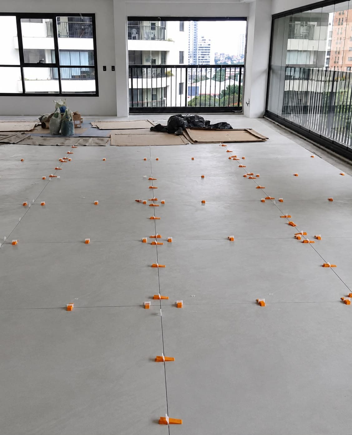 Colocação de porcelanato com niveladores em obra de alto padrão
