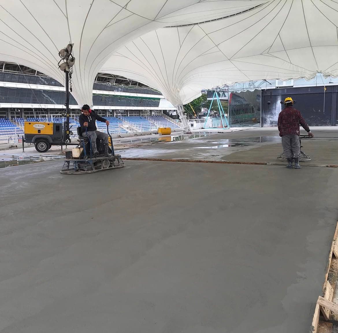 Equipe própria da WR Felix executando piso polido de concreto em estádio esportivo